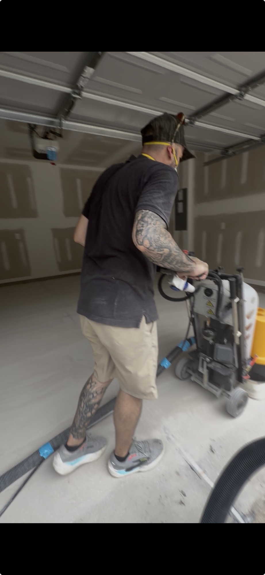 Installer mechanically grinding a concrete garage floor before coating