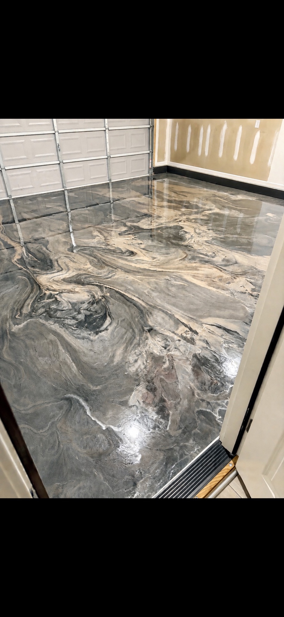 Gray metallic epoxy garage floor viewed from the entry door