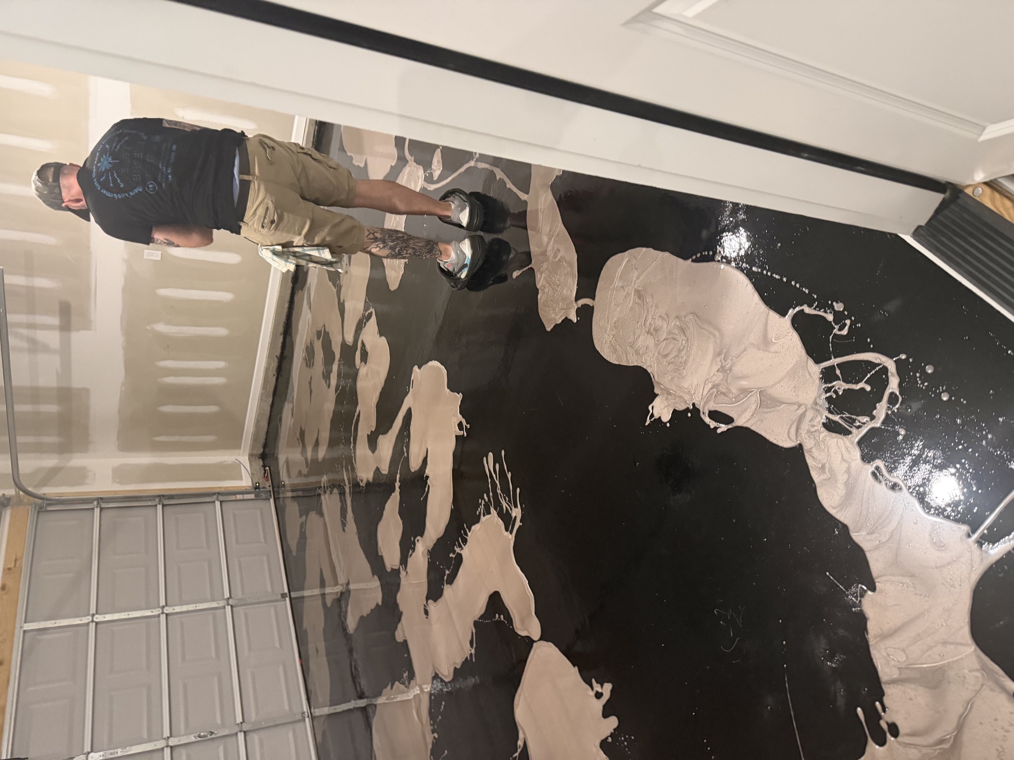 Installer creating a metallic coating pattern across a garage floor