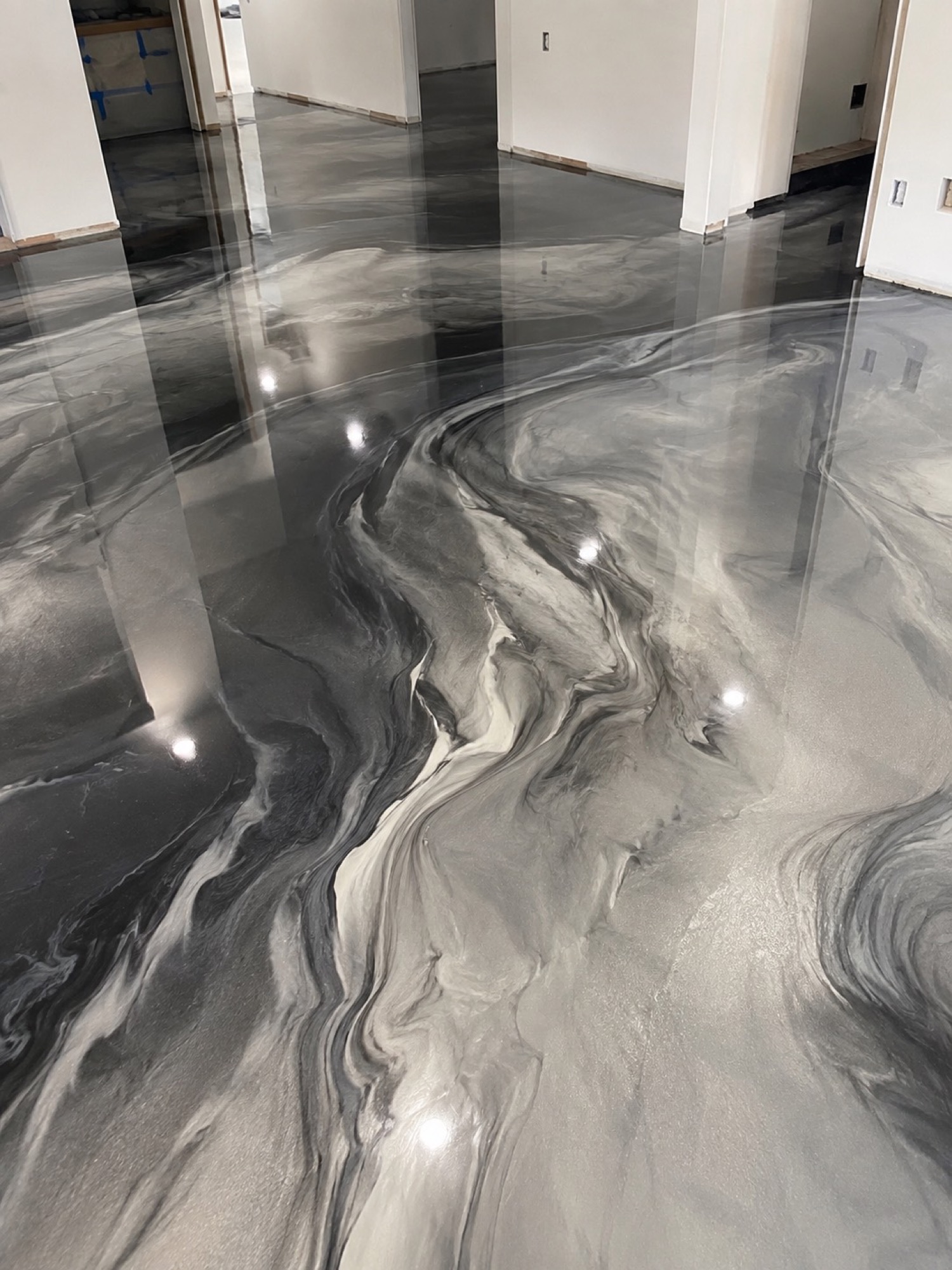 Glossy gray and black metallic epoxy across an open interior floor